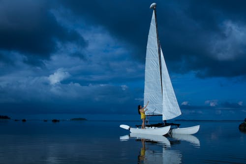 Женщина, стоящая на белой лодке