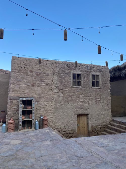 Free Rustic stone house facade with lanterns and pottery against a twilight sky. Stock Photo