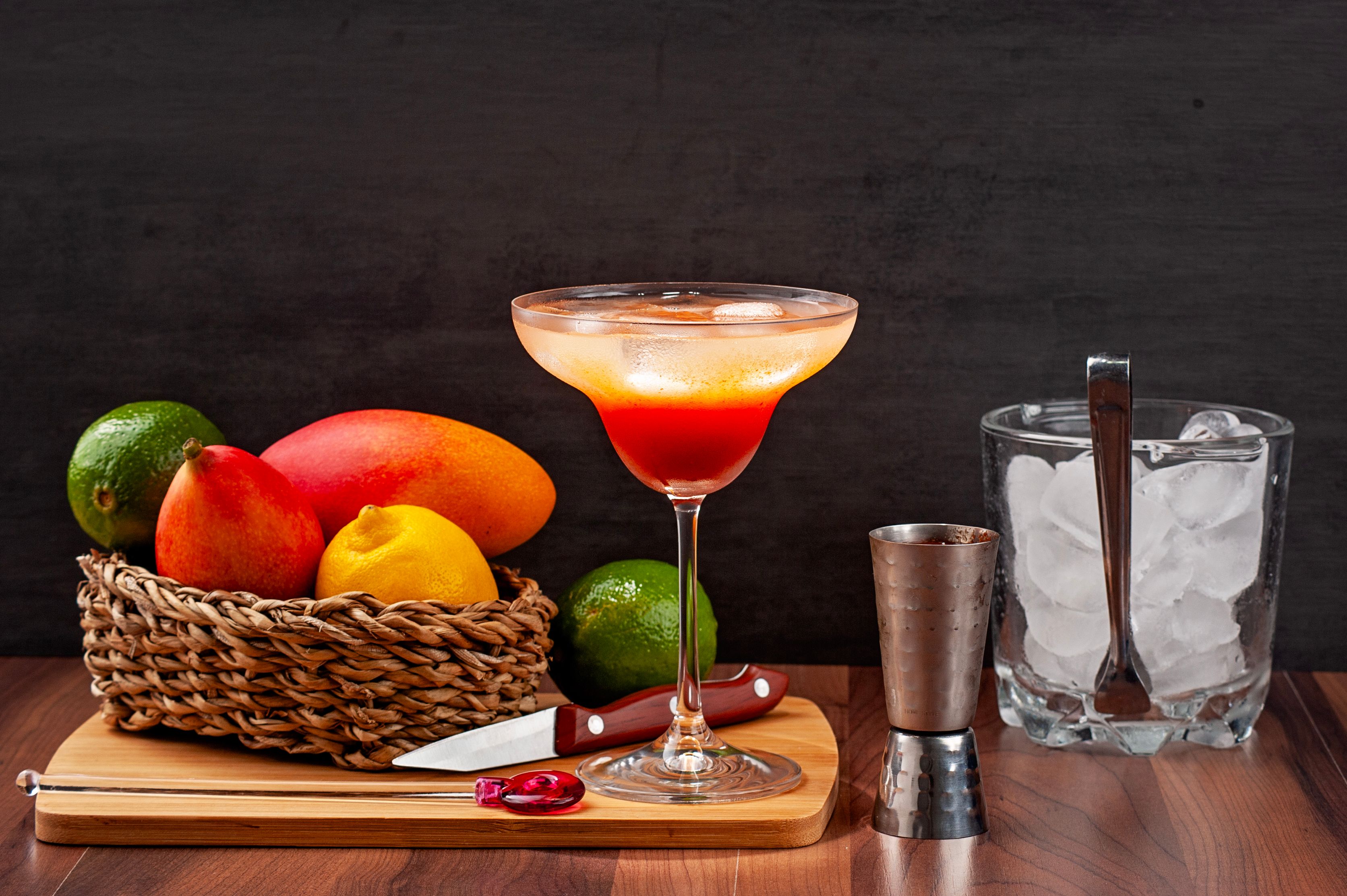 Close-up view of a vibrant Miami Vice cocktail showing half white pia colada and half pink strawberry daiquiri in a tropical setting