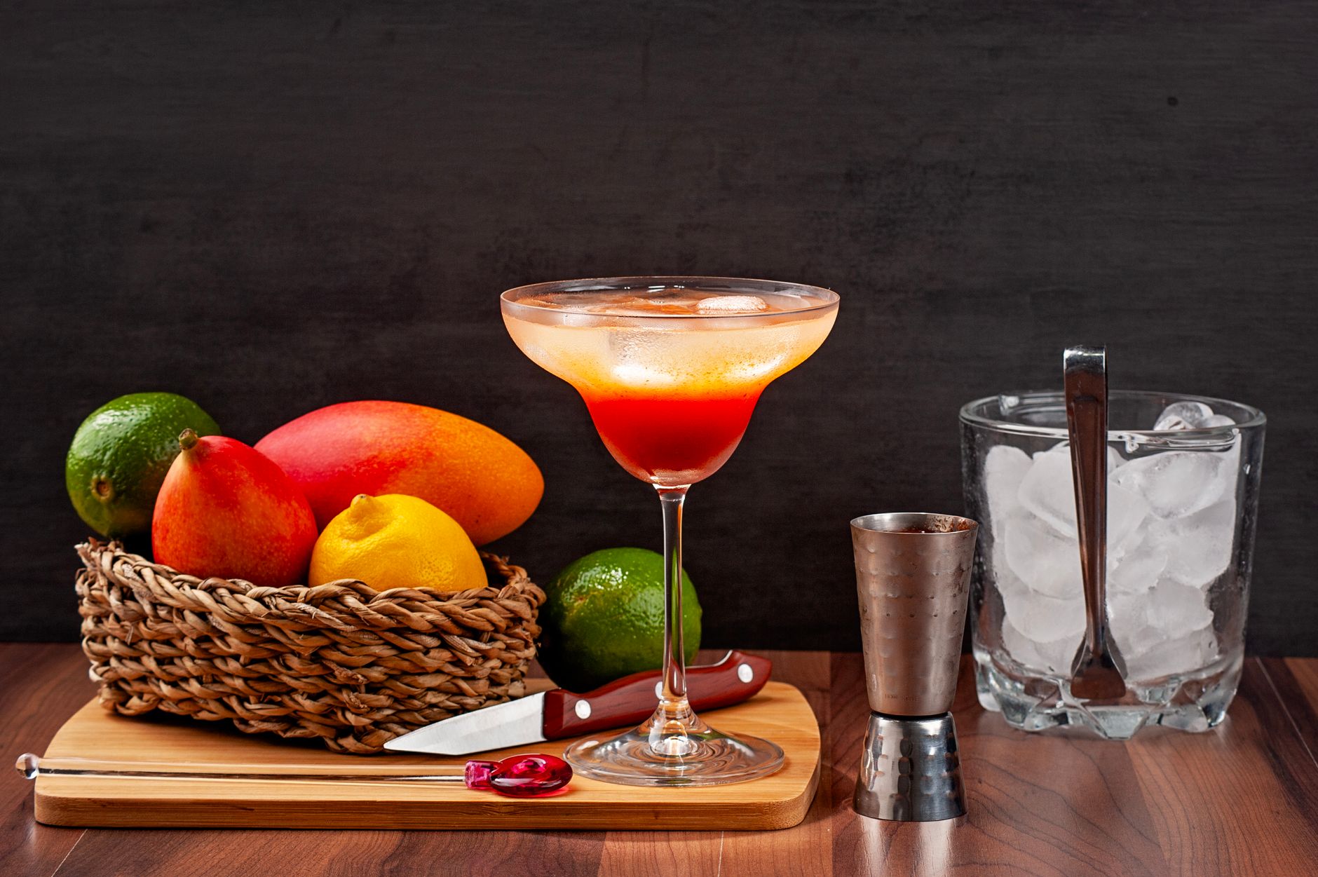 Close-up view of a vibrant Miami Vice cocktail showing half white pia colada and half pink strawberry daiquiri in a tropical setting