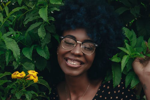 Smiling Woman Posing Near Green Plants