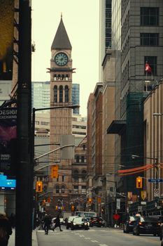 Capture of Toronto's busy street with the iconic clock tower in the background, emphasizing urban life.