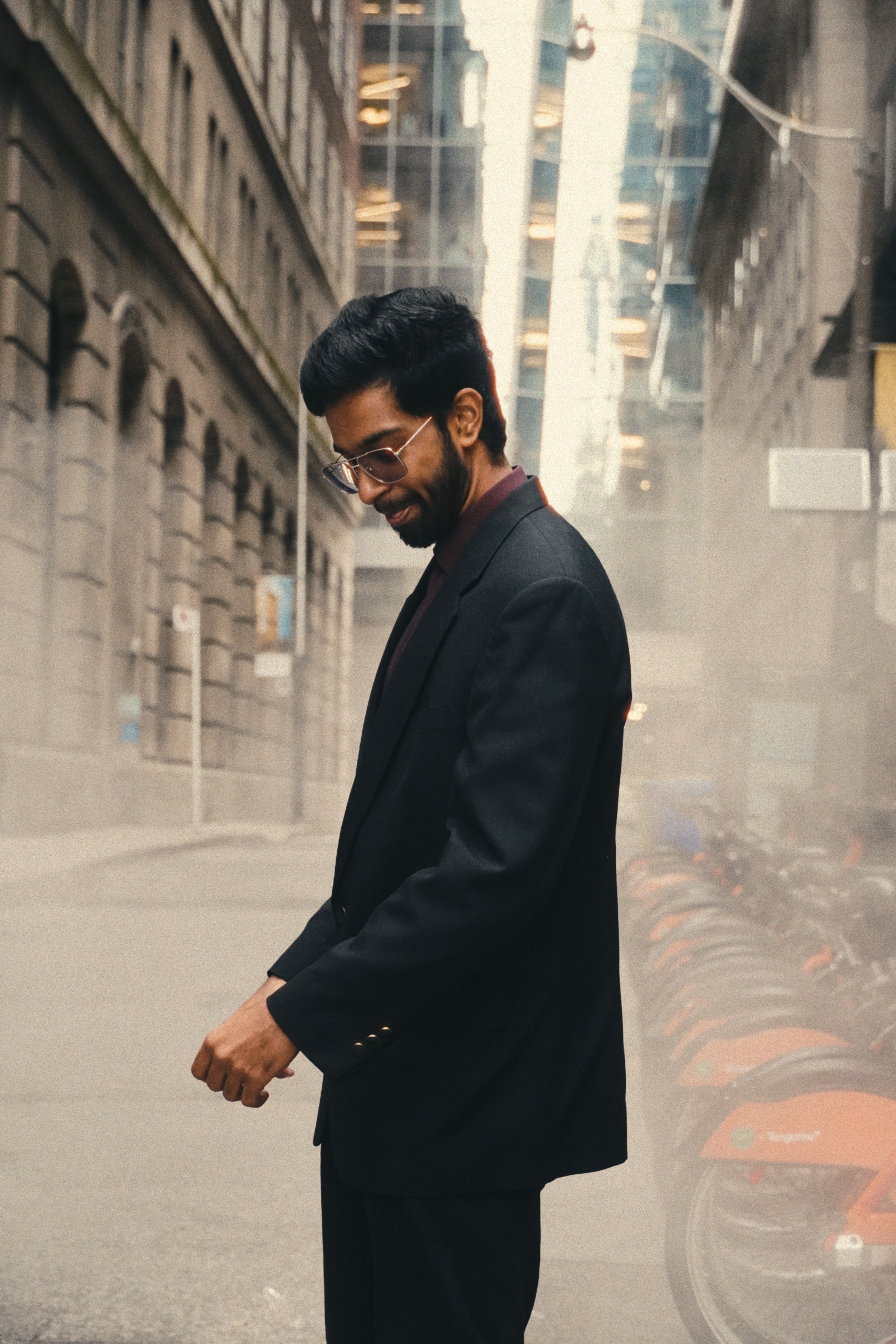 A well-dressed man walks through a foggy downtown Toronto street, capturing urban elegance.