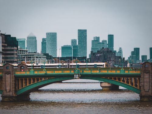 Free Southwark Bridge spanning the Thames with London's modern skyline in the background. Stock Photo