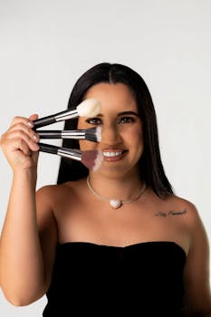 Smiling woman with makeup brushes showcasing beauty and self-expression.