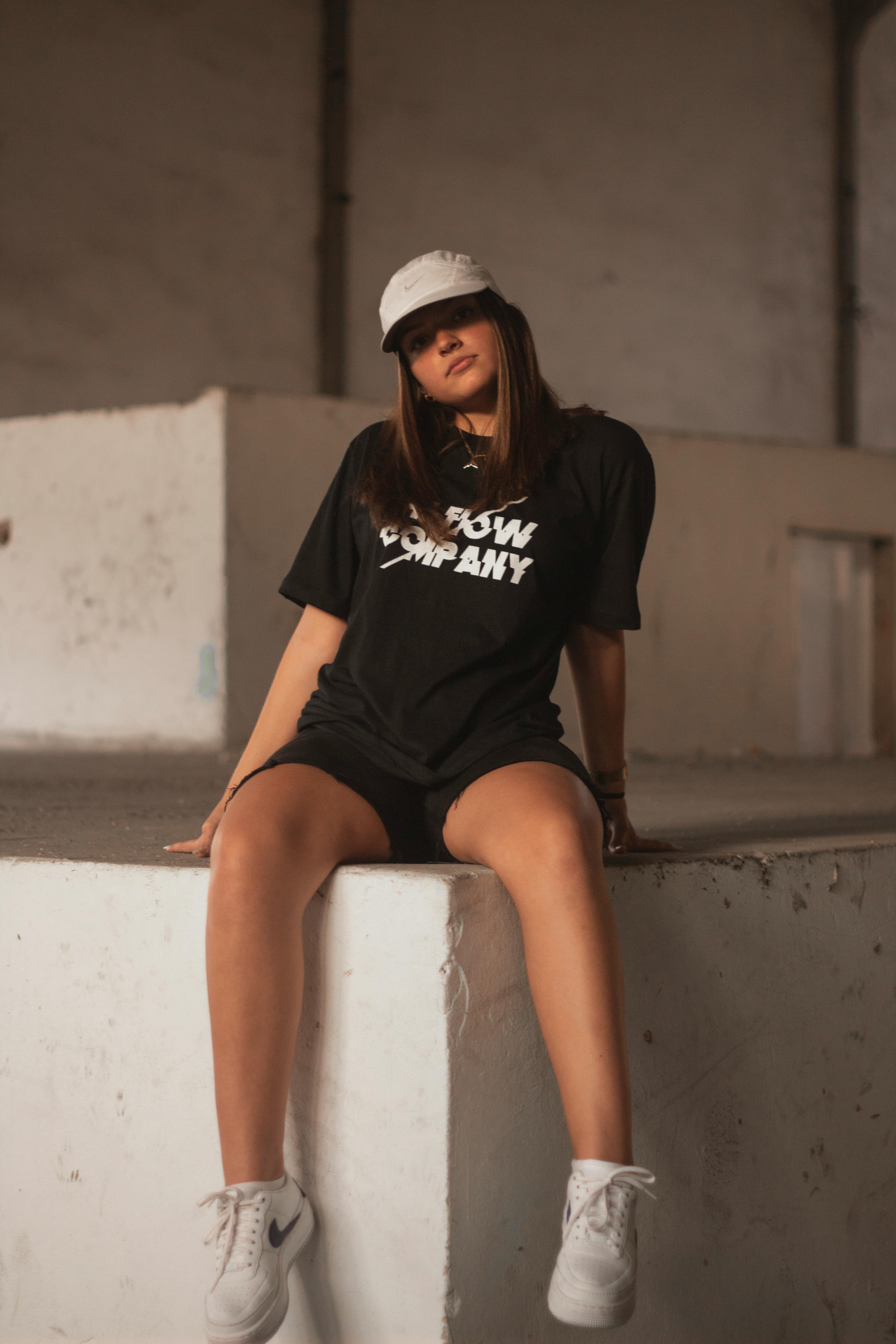 Photo of Woman in Black Top and Black Shorts Sitting Alone on Concrete ...