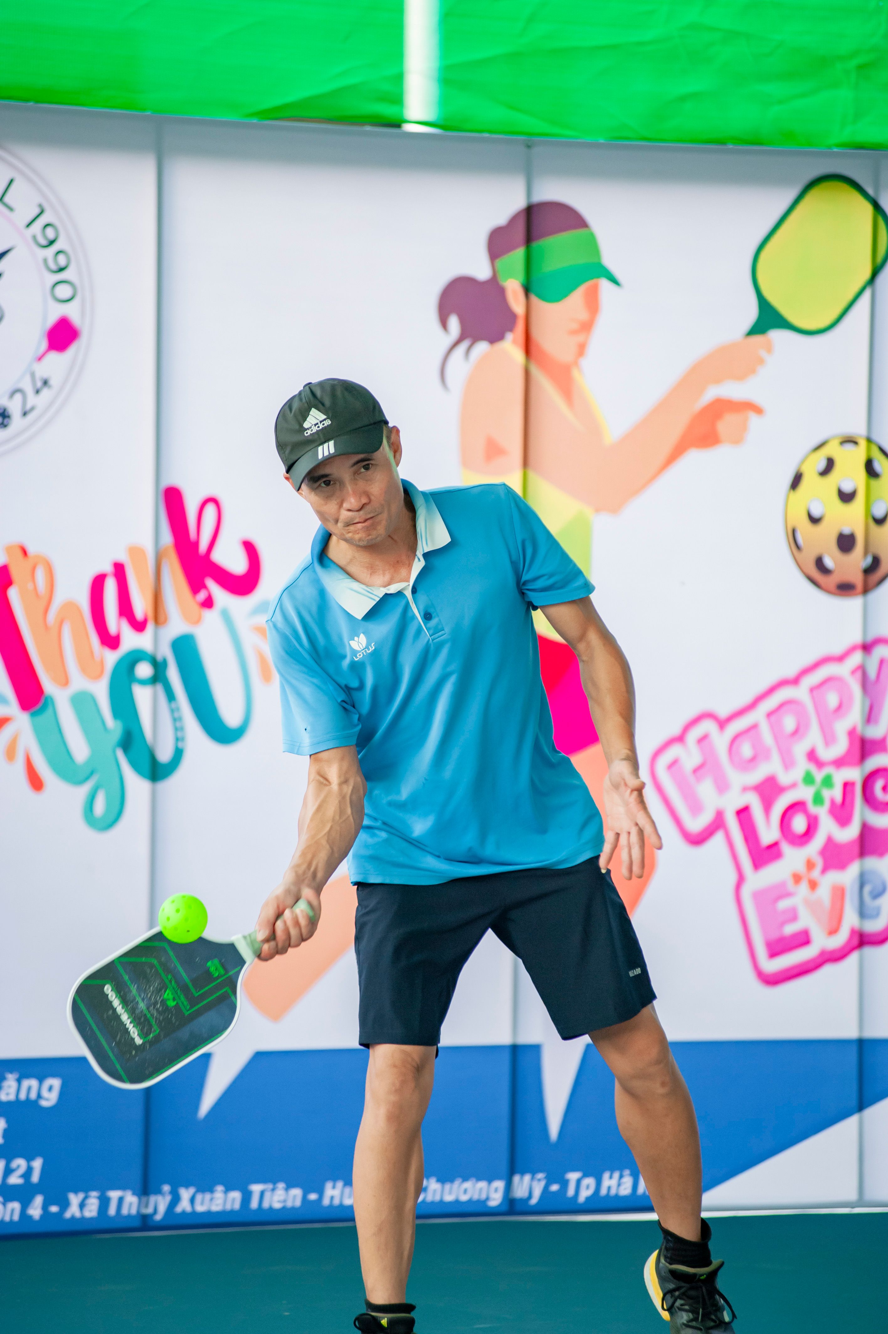 Dynamic pickleball action shot of a man playing indoors in Hà Nội, Vietnam.