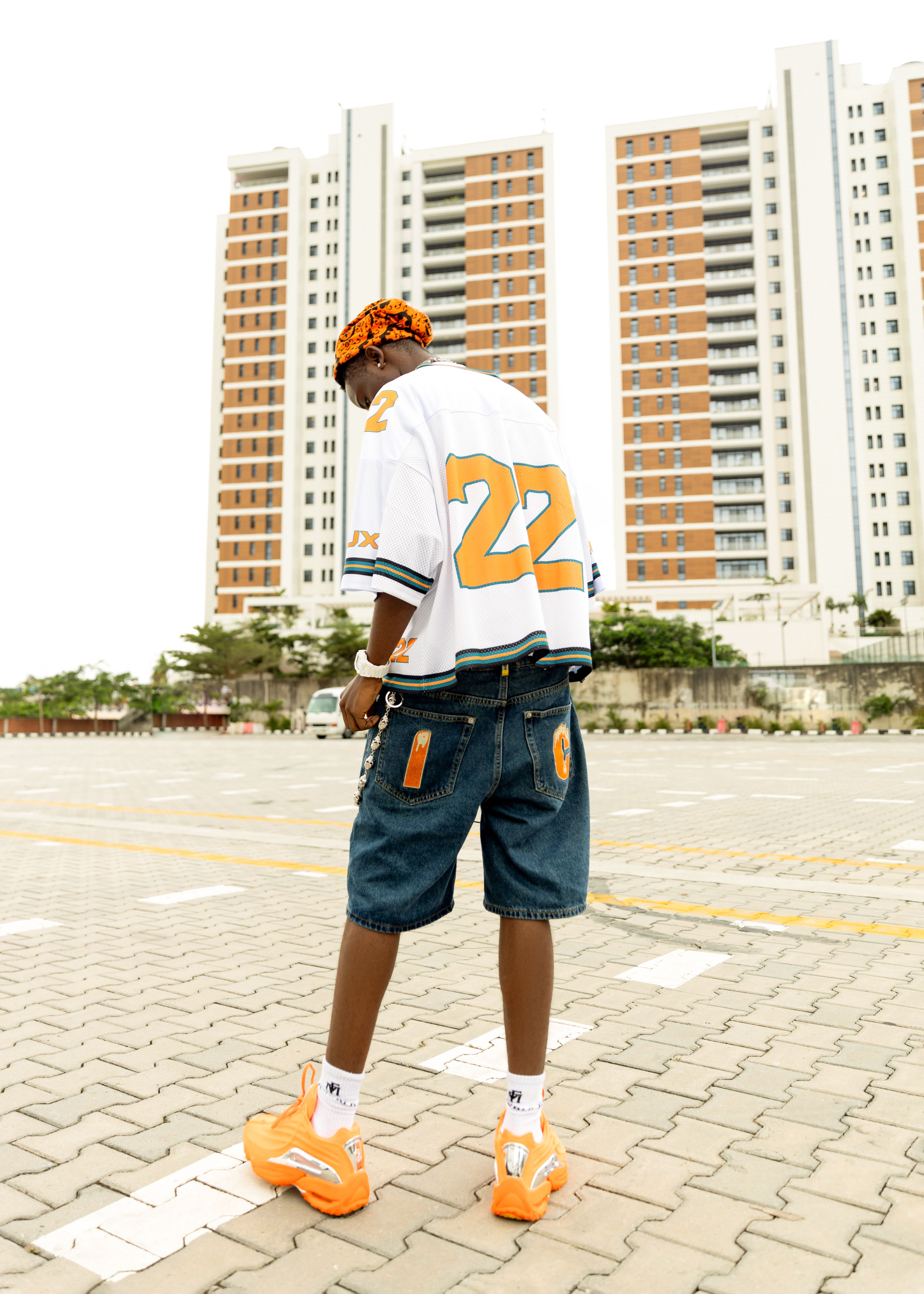 Stylish young man in urban fashion with high-rise buildings in the background.