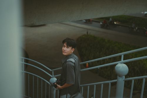 Free Candid portrait of a photographer on a staircase in Ho Chi Minh City, Vietnam. Stock Photo