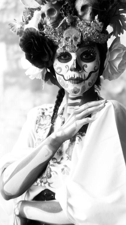 Free Striking Catrina portrait in traditional makeup and elaborate floral headdress. Stock Photo