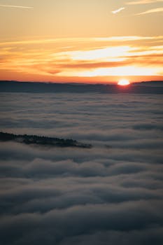 A breathtaking sunrise above a sea of clouds creating a serene and peaceful landscape.