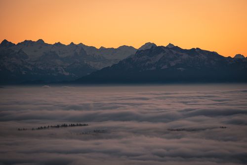 Free Scenic sunset over misty mountains and clouds creating a mesmerizing landscape. Stock Photo