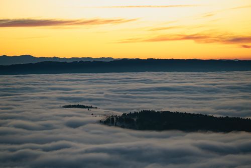 Free Dramatic sunset over a sea of clouds and distant mountains, capturing a serene and tranquil moment. Stock Photo