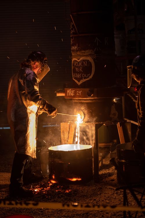 Free A worker pours molten metal in an industrial setup at night in Milwaukee, Wisconsin. Stock Photo
