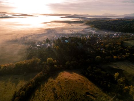 A breathtaking aerial shot of a fog-covered valley at sunrise, showcasing the beauty of nature.