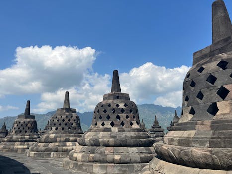 A stunning view of Borobudur Temple stupas under a clear blue sky in East Java, Indonesia.