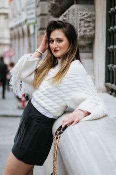 Stylish woman poses outdoors in Istanbul, wearing chic fall fashion against historic architecture.
