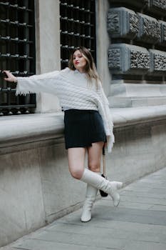 Fashionable young woman in Istanbul poses in a chic outfit by a textured wall.