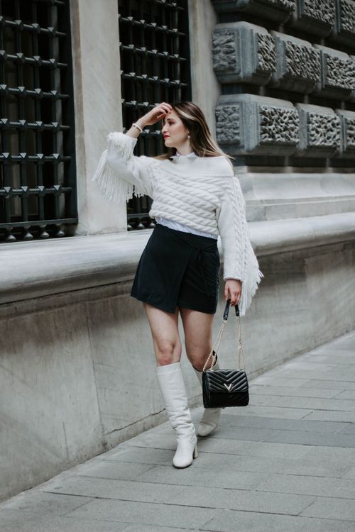 Free Fashionable woman in white sweater and boots strolling a historic street in Istanbul. Stock Photo