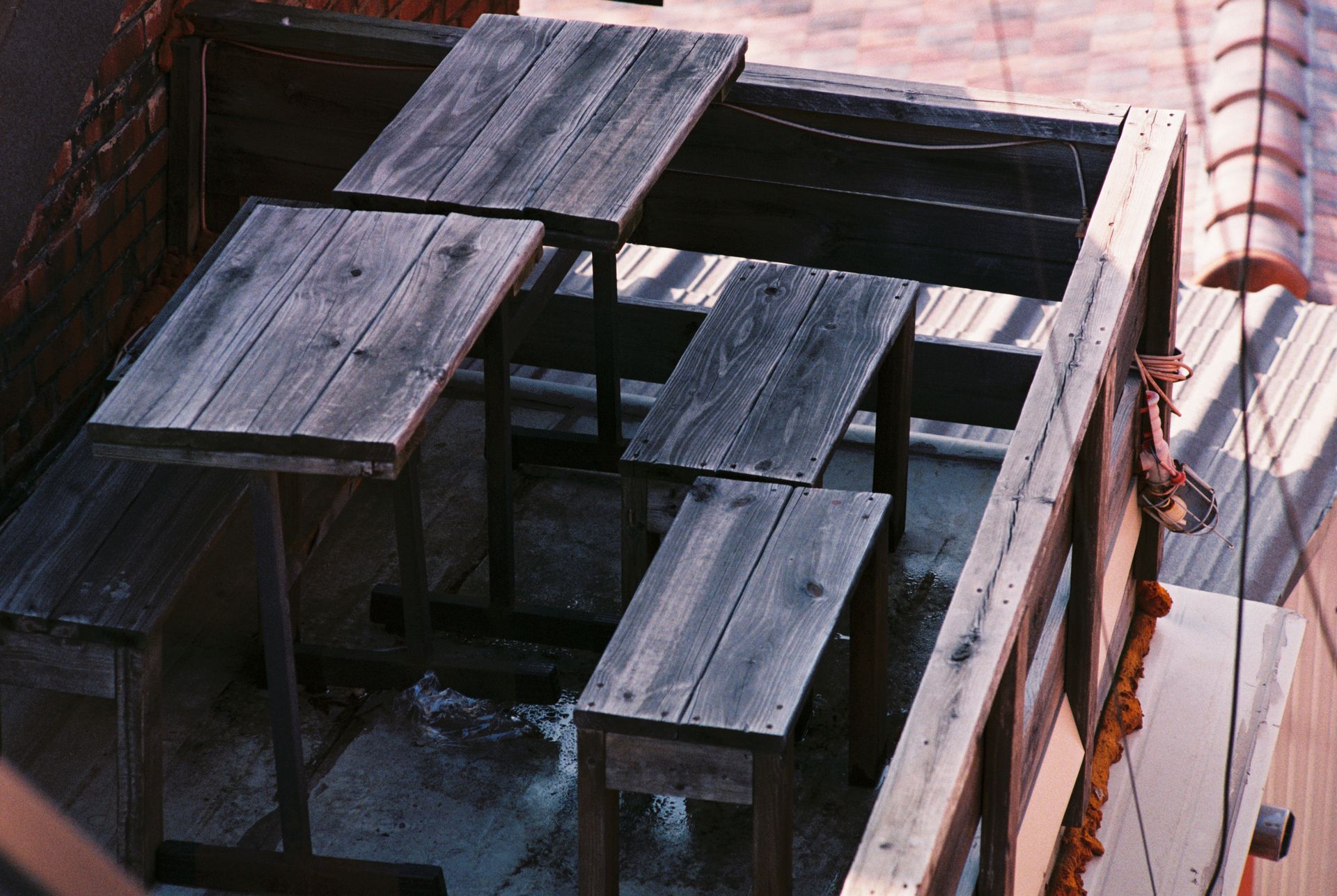 Rustic wooden picnic tables and benches on a rooftop in Seoul, South Korea.