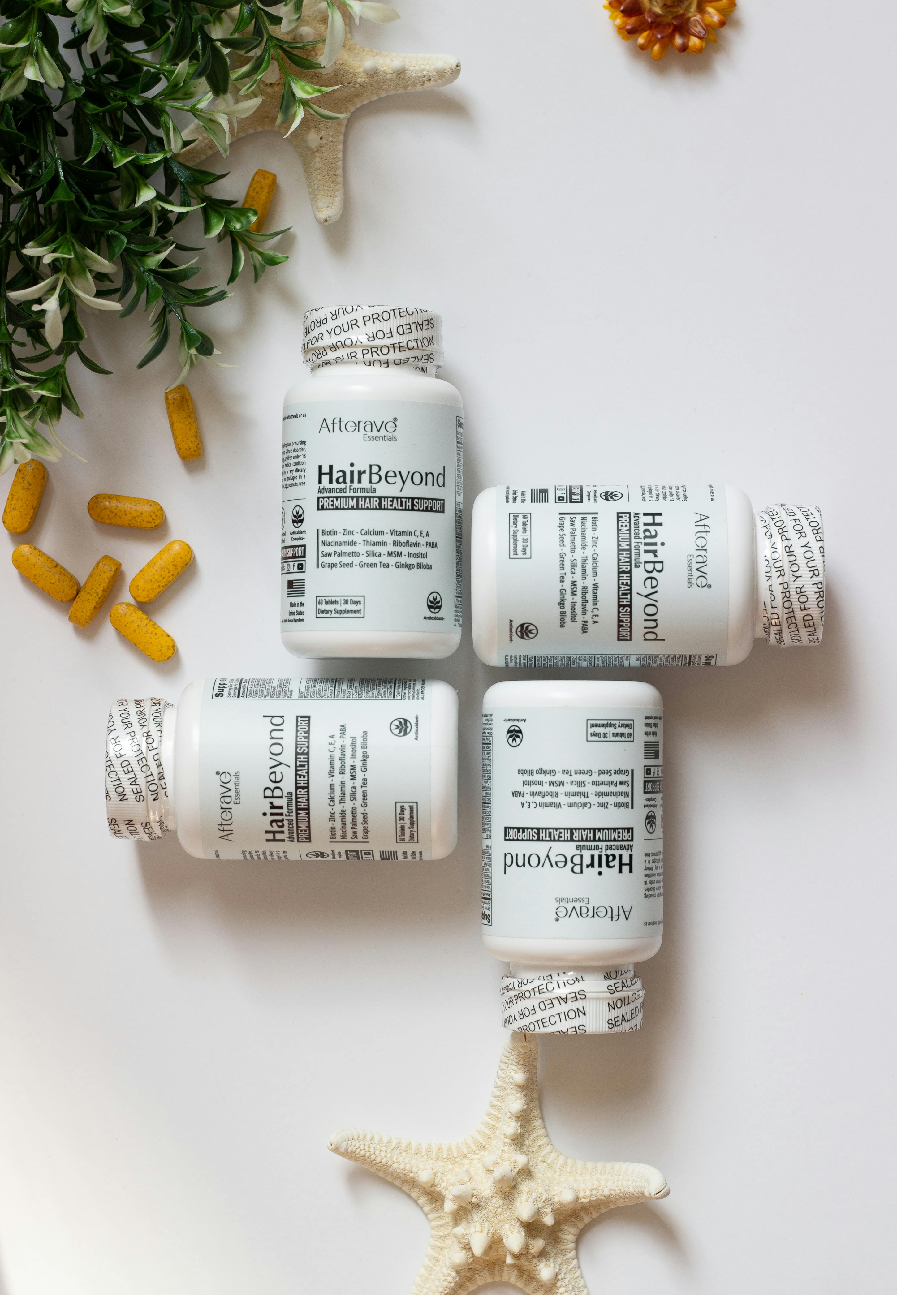 Hair growth supplement bottles and capsules with greenery and starfish decor.