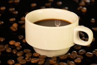A classic white cup of black coffee surrounded by coffee beans on a dark background.