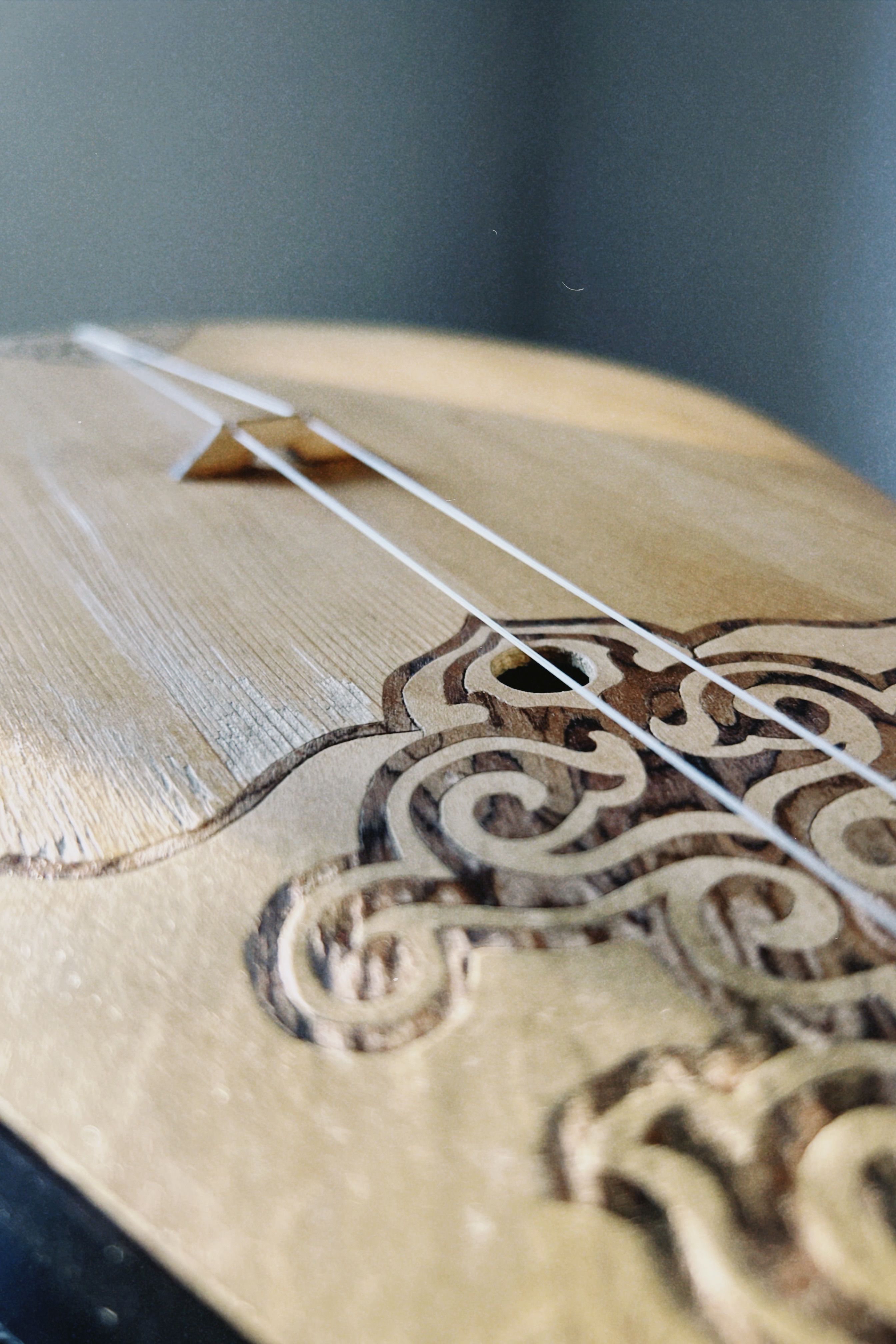 Detailed shot of a Kazakh dombyra showing intricate wood carving and strings.