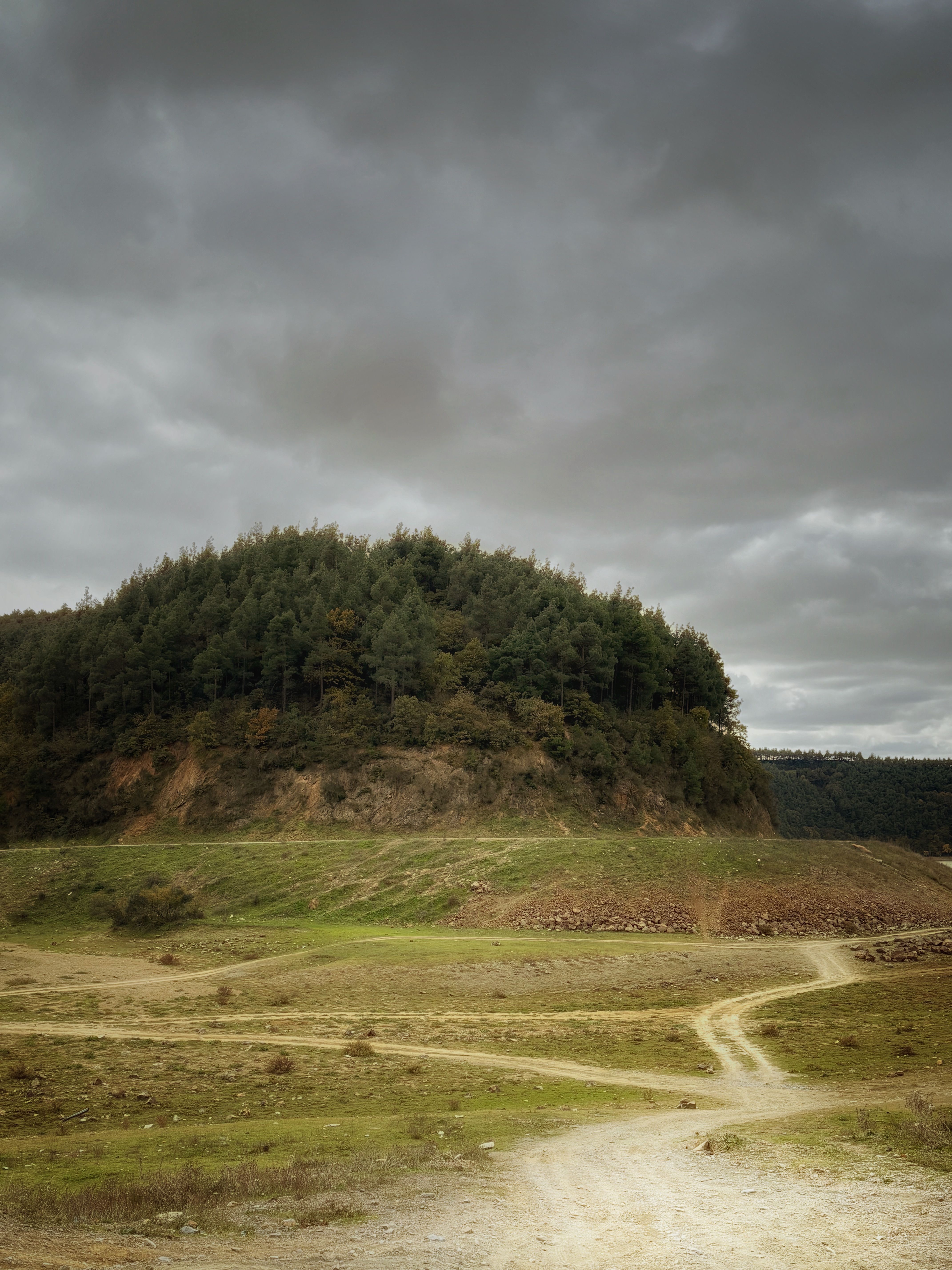 Dramatic Landscape of Green Hill under Moody Skies · Free Stock Photo