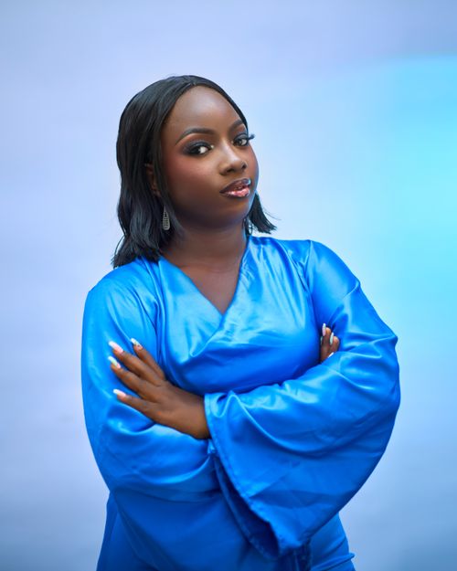 Free Elegant portrait of a confident woman in a vibrant blue dress with folded arms. Stock Photo