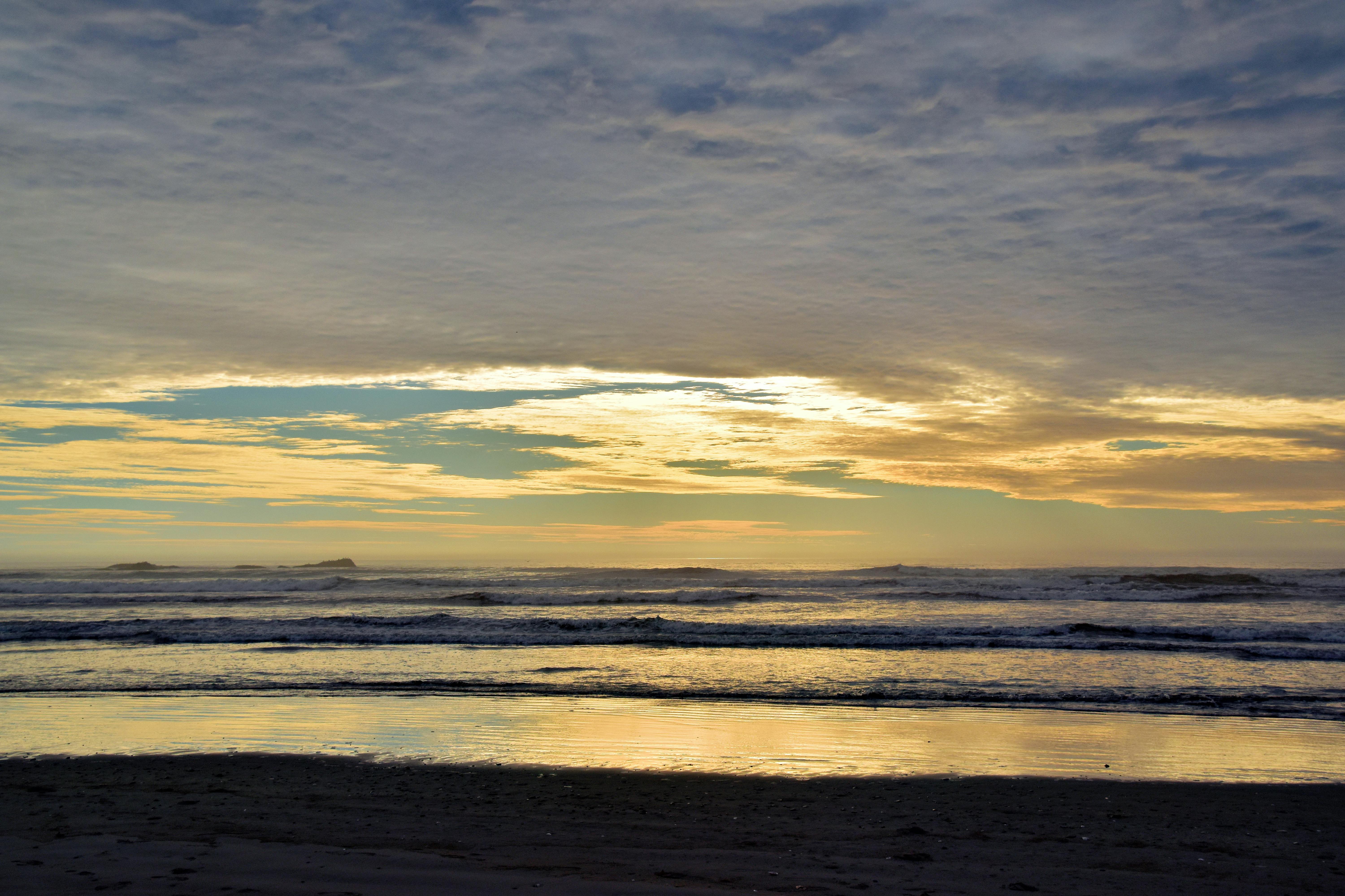 Peaceful sunset view over Kalaloch Beach with gentle waves and colorful sky.