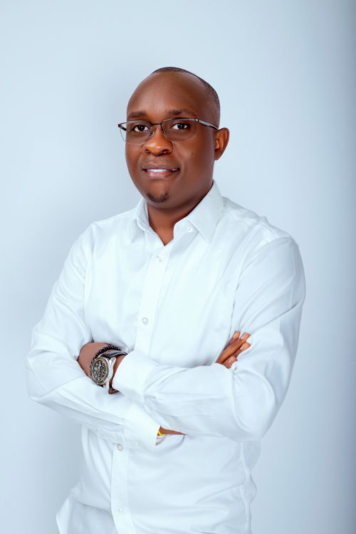 Free Professional portrait of a smiling man in a white shirt with folded arms against a light background. Stock Photo