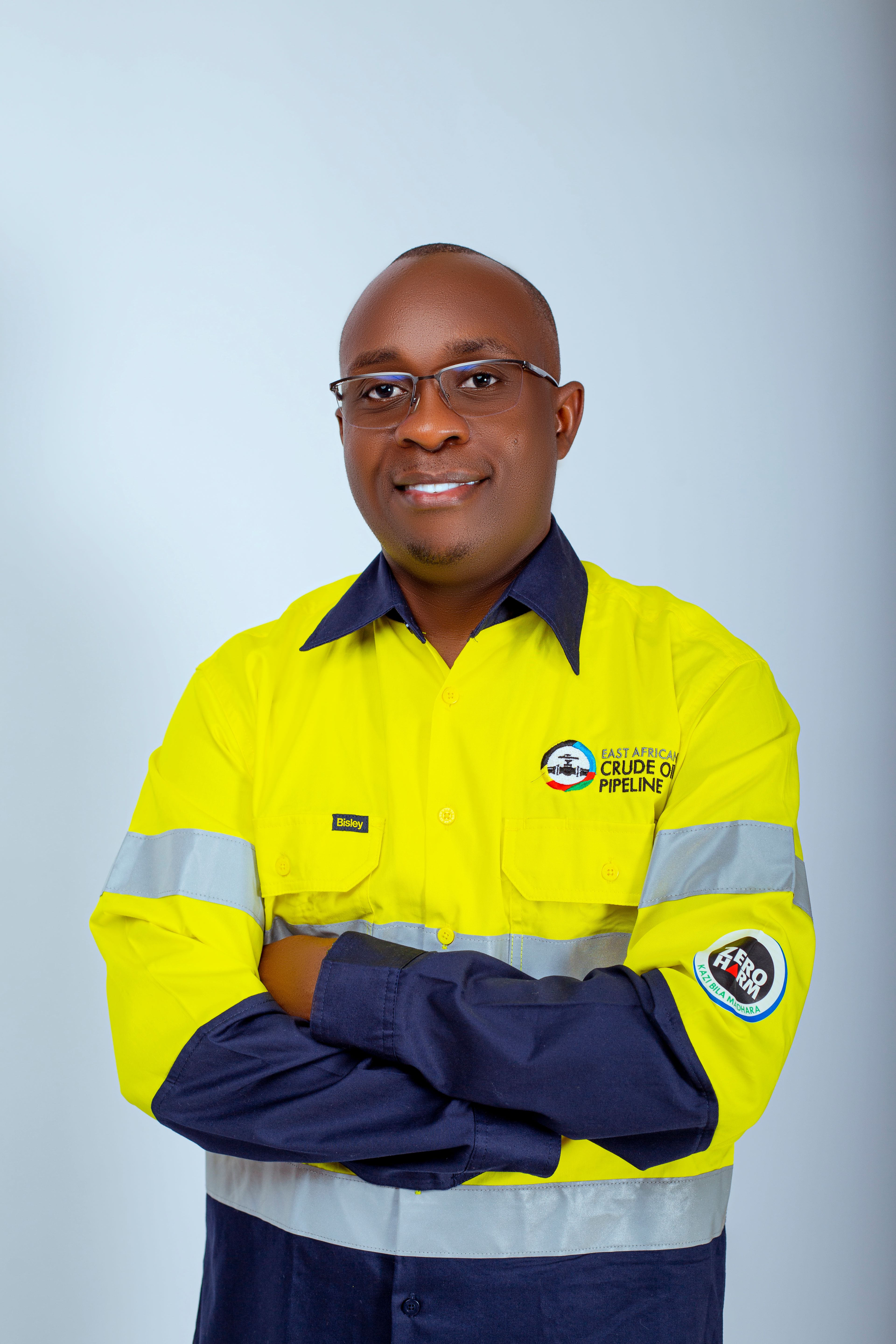 Confident industrial worker in high-visibility uniform, smiling at the camera.