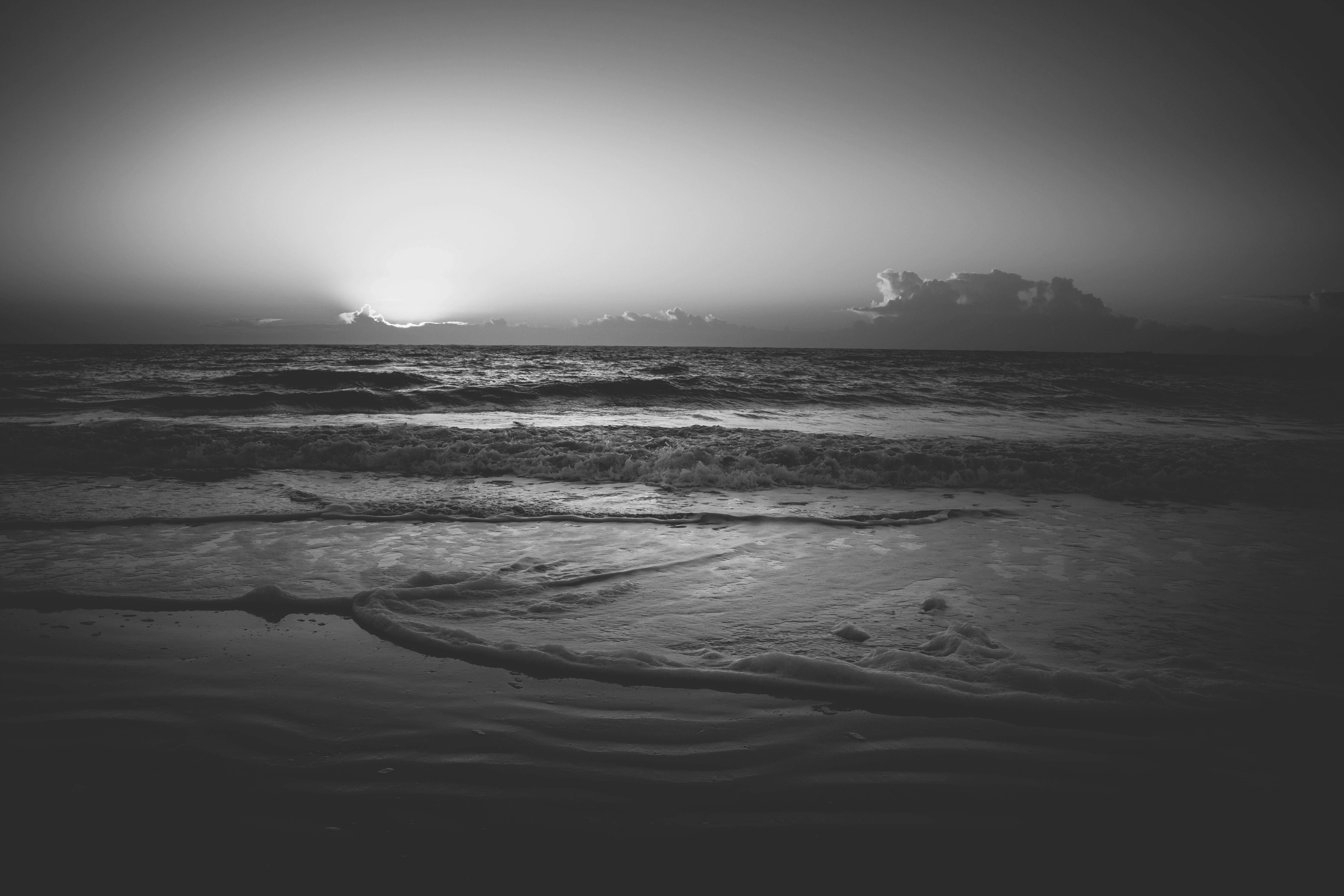 免費 迷人的黑白照片，寧靜的海洋日落與柔和的波浪。 圖庫相片