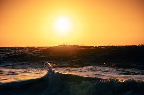 Free Capture of ocean waves against a vivid sunset sky, evoking a sense of tranquility and drama. Stock Photo