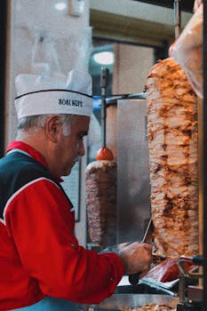 Chef slicing döner kebab at an Istanbul street food stall. Authentic Turkish cuisine experience.
