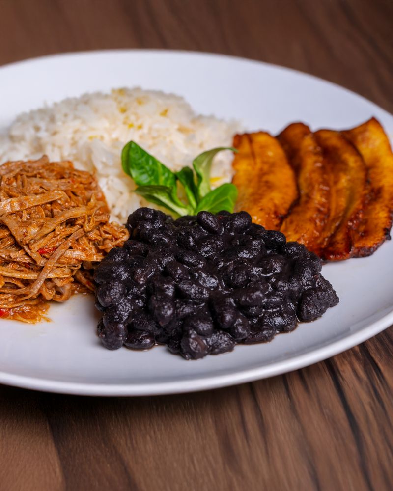 Plat typique nicaraguayen — riz, haricots noirs, plantain frit et viande effilochée