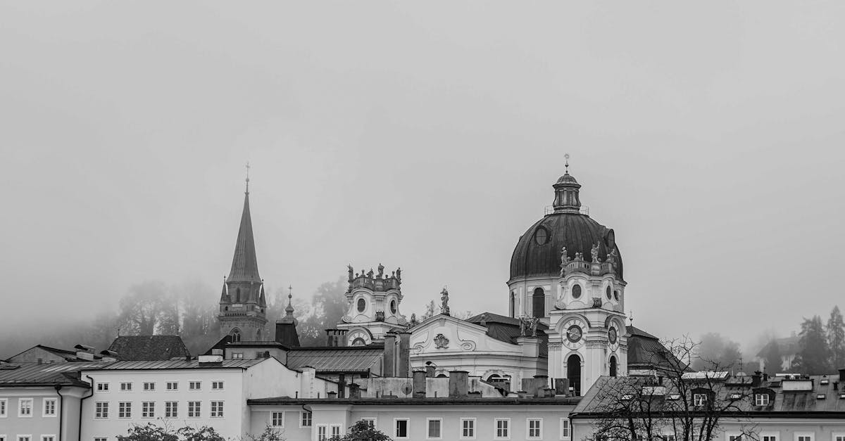 Black and white view of Salzburg's historic architecture shrouded in mist.