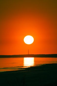 A peaceful sunrise over the Baltic Sea at Krynica Morska, Poland with a warm orange glow.