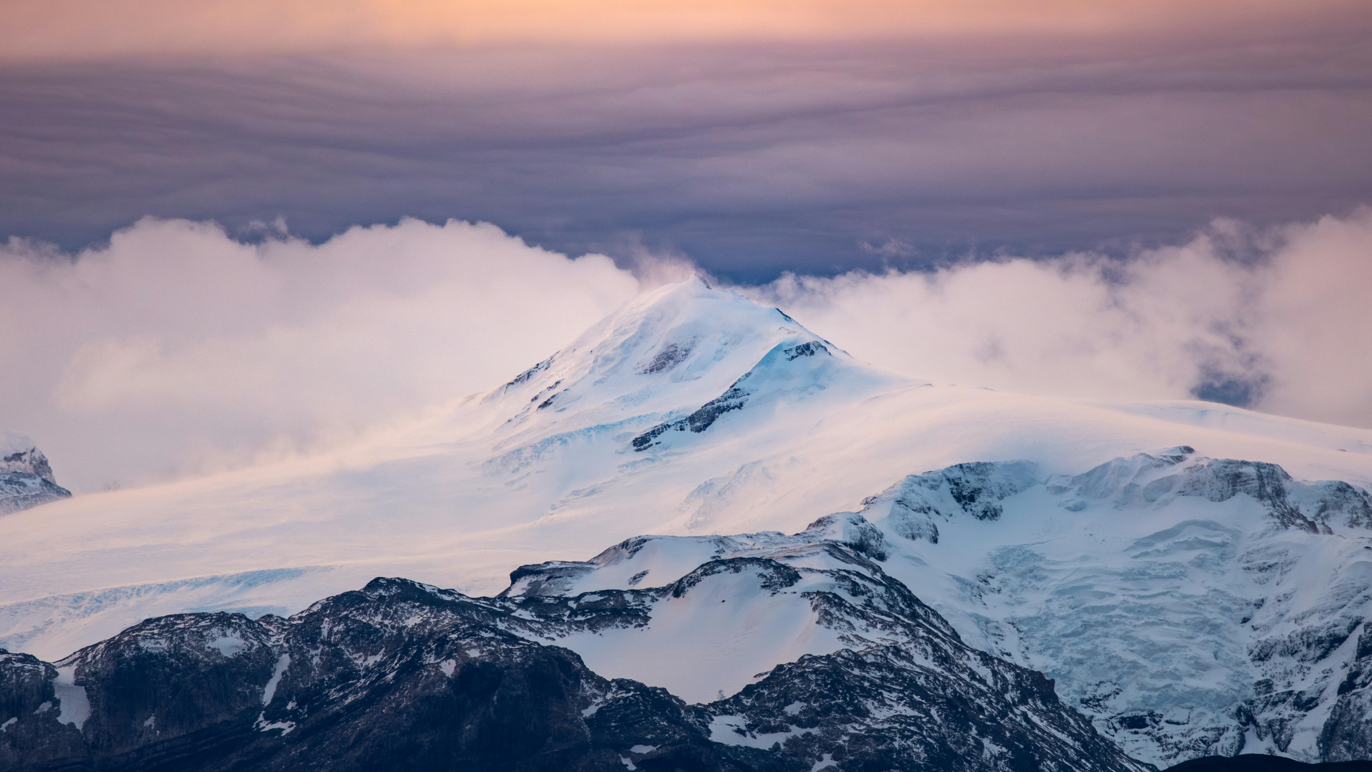 Prescription Goggle Inserts - Stunning view of a snow-covered mountain peak in Chilean Patagonia at sunset, enveloped in clouds.