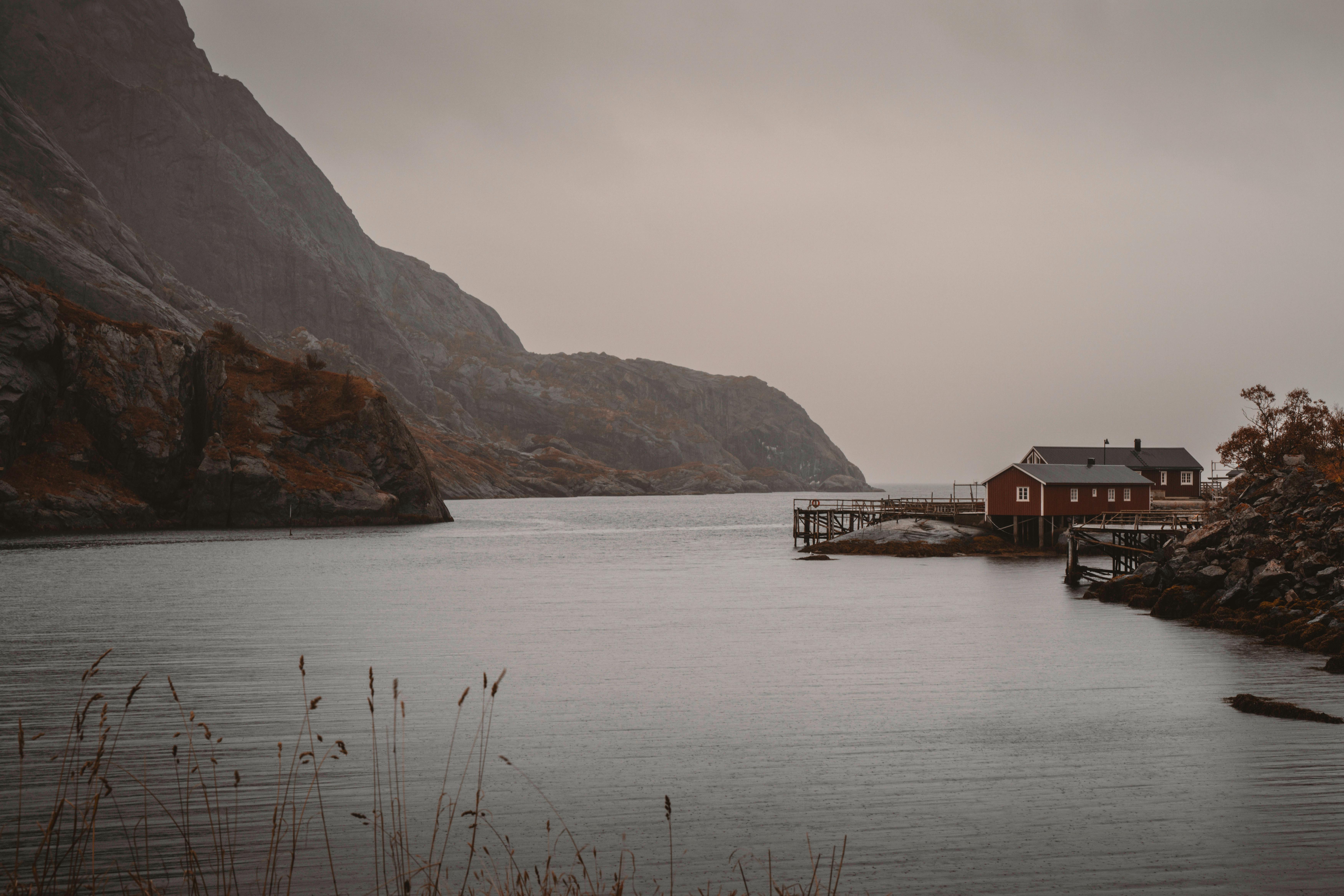 Tranquil autumn waterscape with red cabin in Lofoten Islands, Northern Norway.