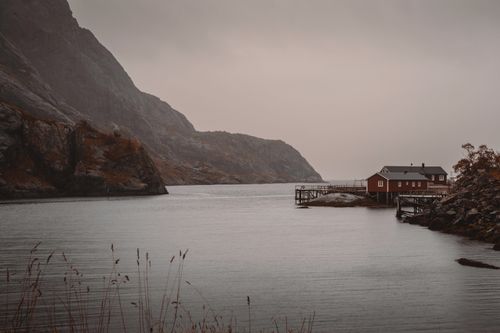 Free Tranquil autumn waterscape with red cabin in Lofoten Islands, Northern Norway. Stock Photo