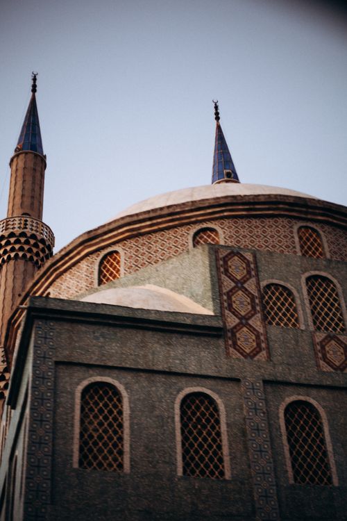 Free View of a beautiful mosque dome and minarets with intricate designs during sunset. Stock Photo