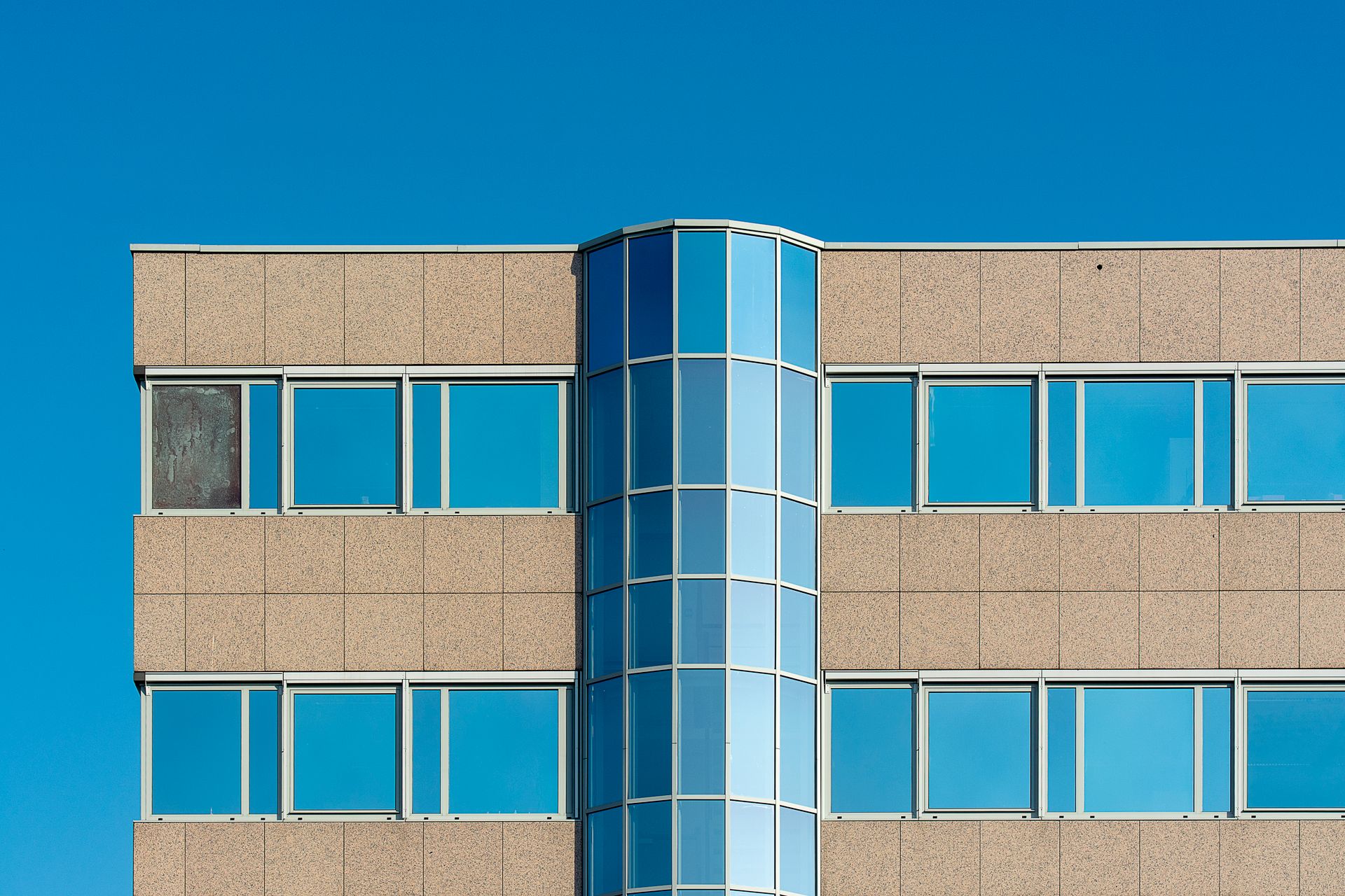 Close-up of a modern office building facade with blue glass windows in Voorburg, Zuid-Holland.