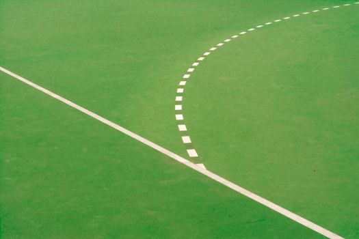 Minimalist abstract image showcasing lines on a green sports field.