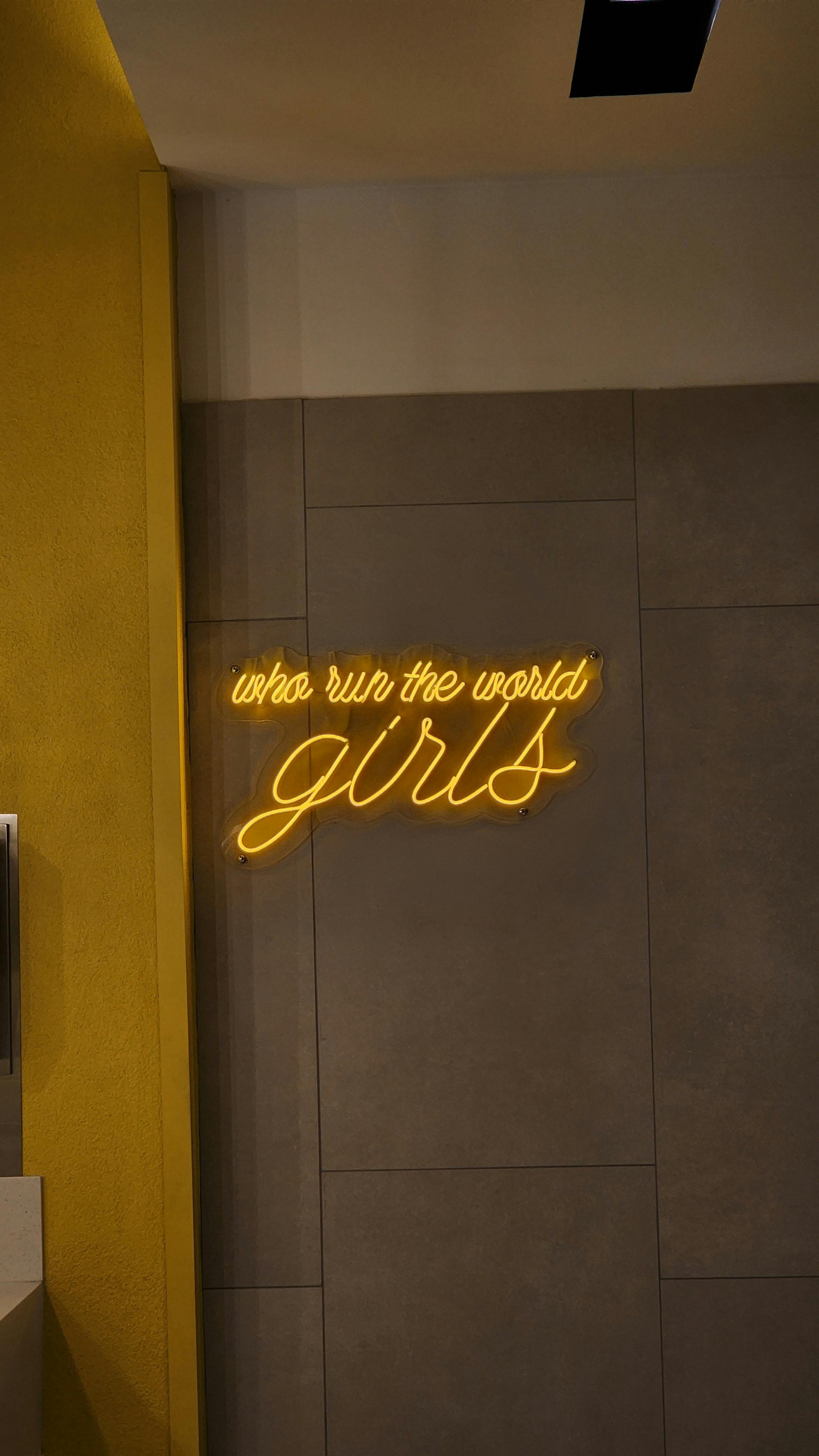 Free Stylish neon sign quoting 'who run the world? girls' on a modern wall. Stock Photo