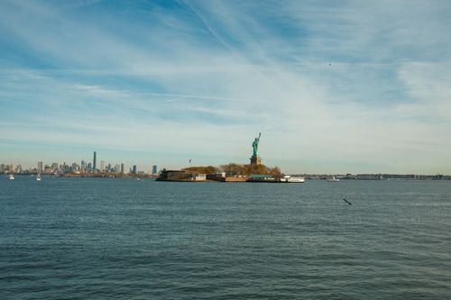 Free View of the Statue of Liberty with the New York City skyline in the background on a clear day. Stock Photo