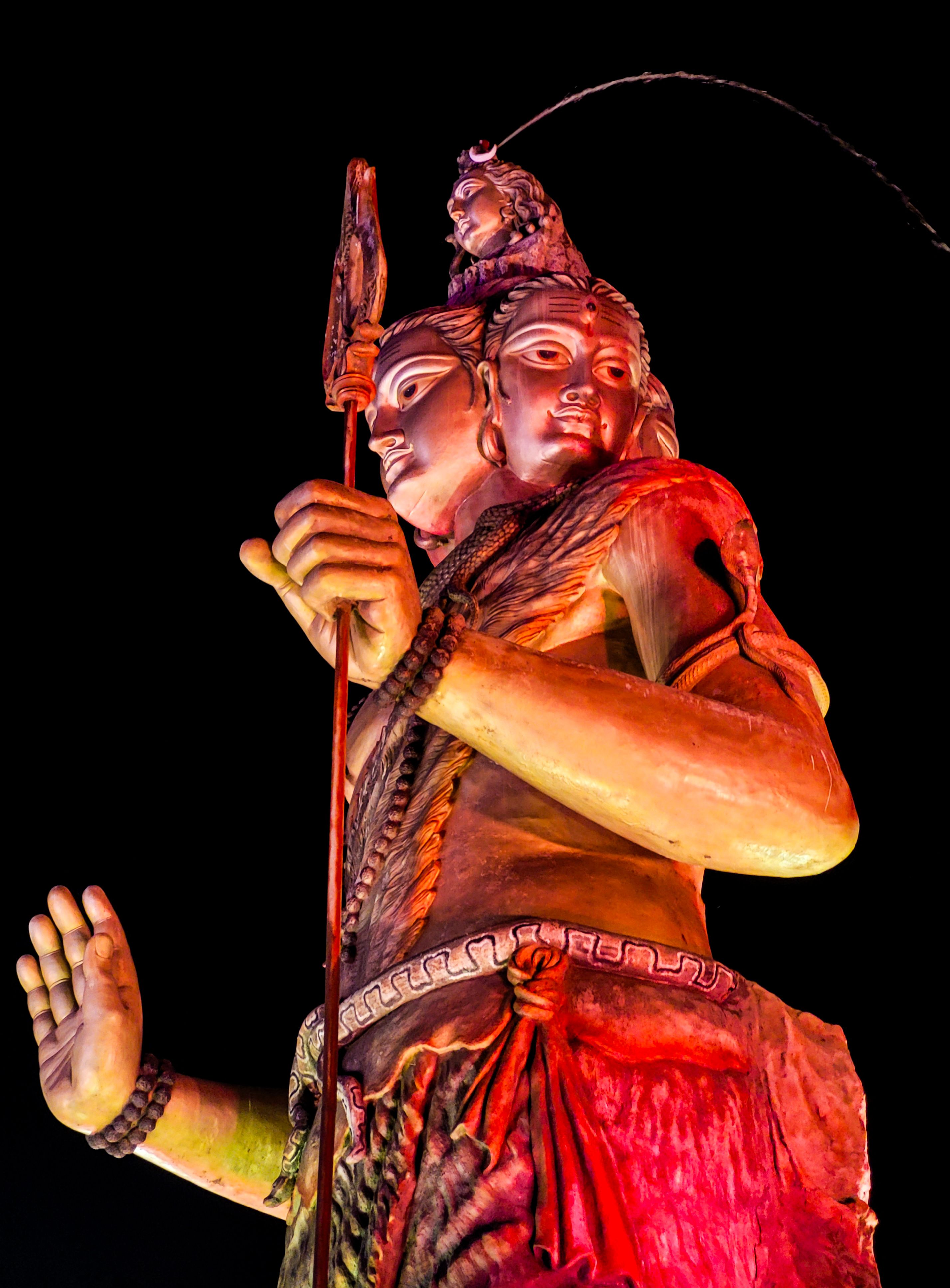 A vibrant and dramatic image of the Lord Shiva statue illuminated under the night sky in Kolkata.