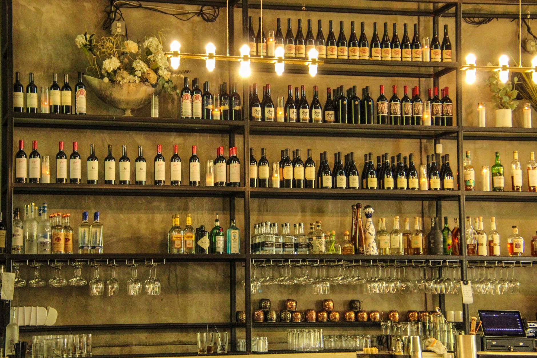 Cozy dimly lit bar with a variety of spirits lining the shelves