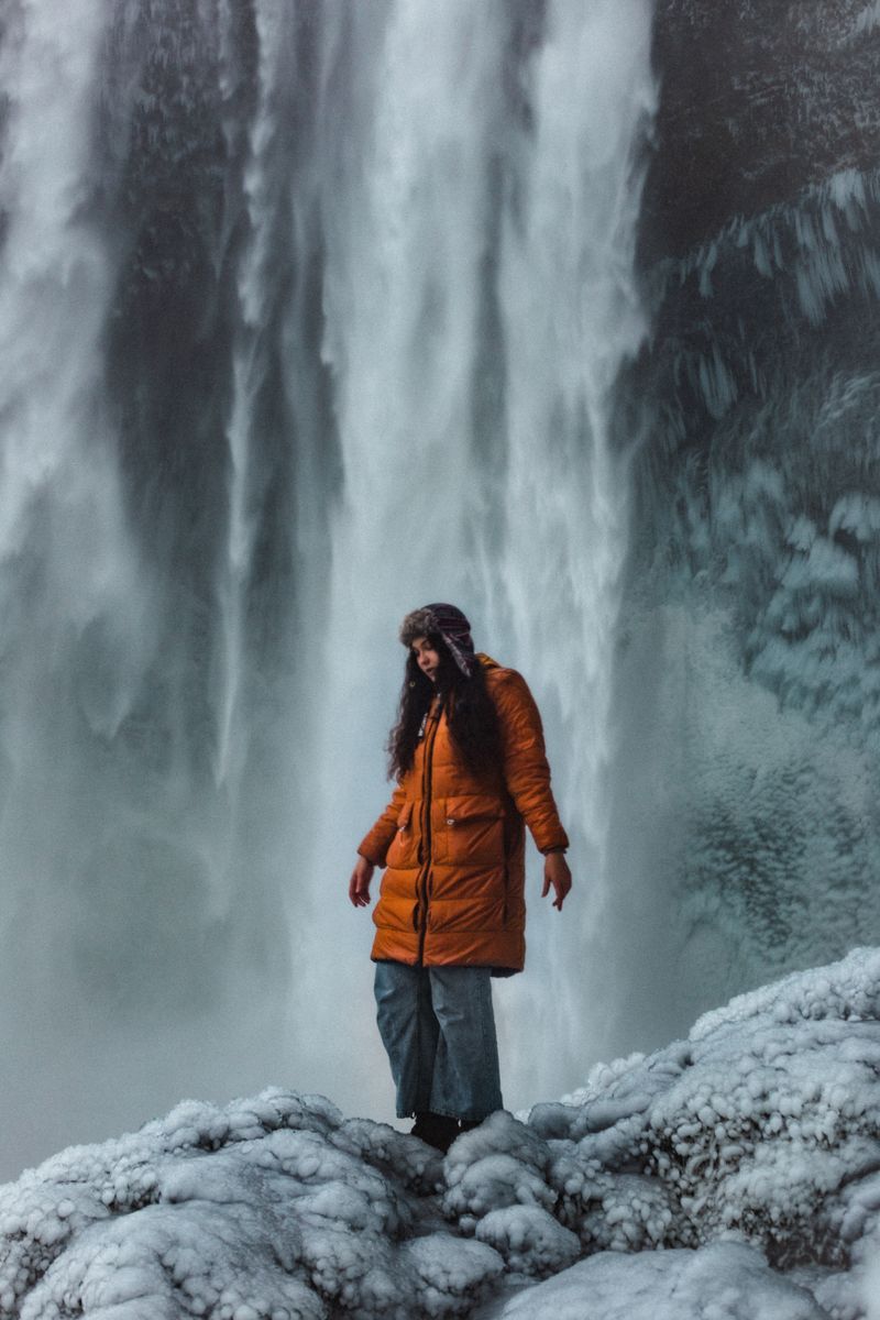 Woman in orange coat in winter landscape