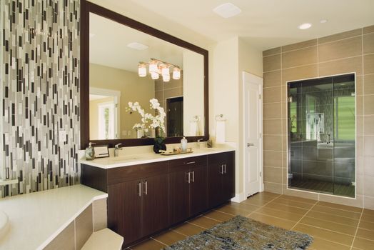 Elegant bathroom featuring modern sink and shower with decorative tiling and large mirror.